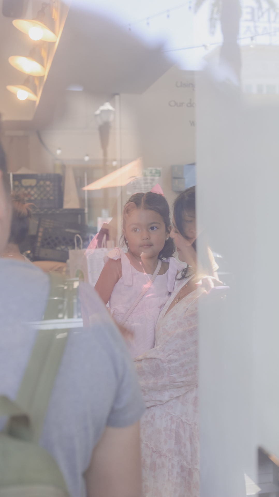 Mother and daughter through a window reflection